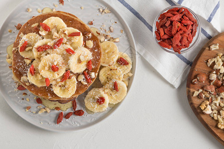 带香蕉核桃果子和蜂蜜的煎饼健康早餐图片