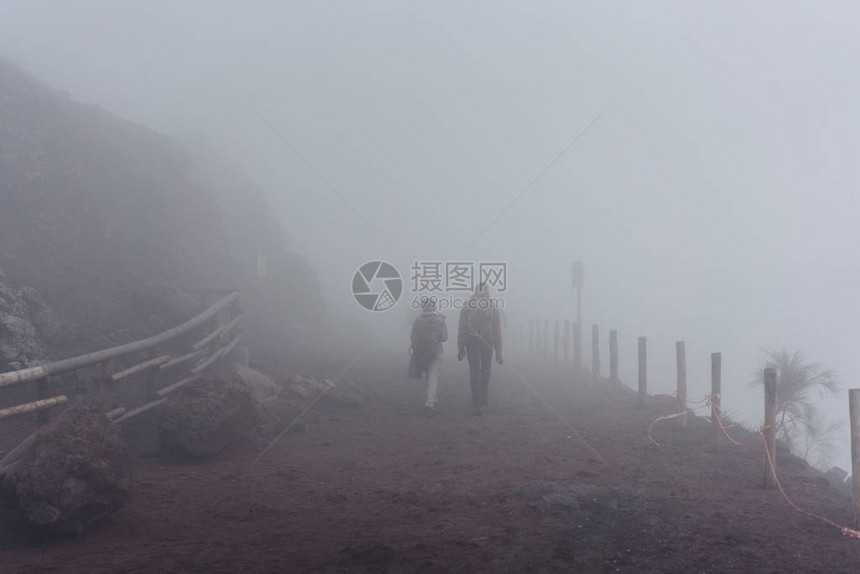 人们爬上山顶在雾中图片