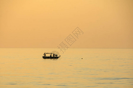 乘轮休游船上的渔民使用渔网在日落图片