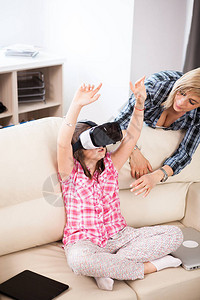 快乐的孩子戴着虚拟现实耳机在妈图片