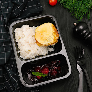 黑色塑料盒装蛋糕和浆果酱的米粥图片