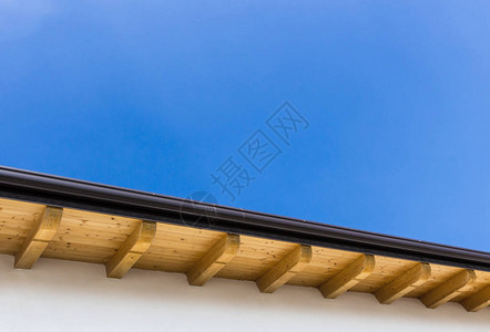 新房子的低角度视图有木屋顶在清蓝背景图片