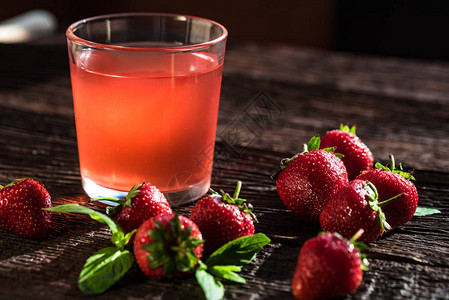 草莓果汁和木本底几片新鲜成熟的草莓图片
