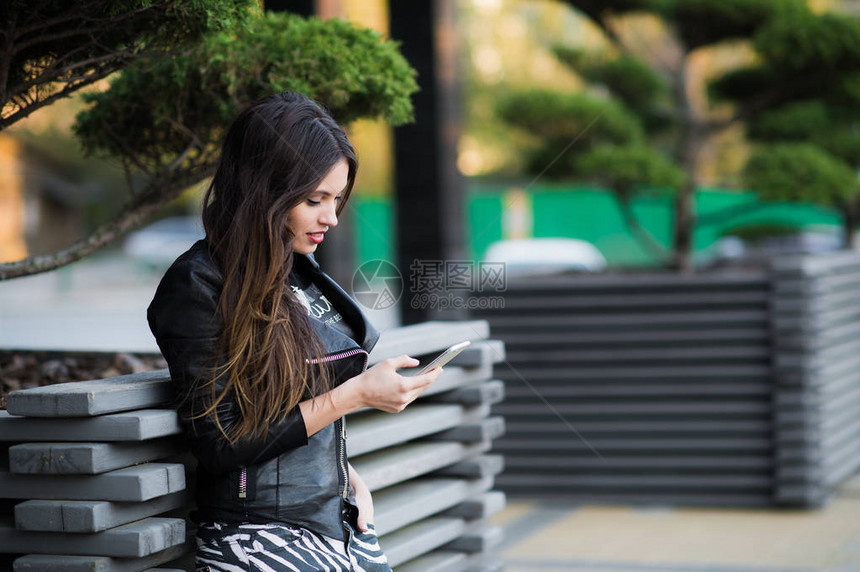 美丽的女人在户外用手机通话图片