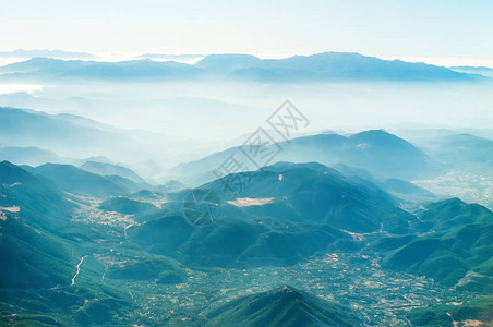 高空从飞机窗口看到山丘云层中的山图片