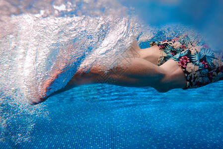 夏天在游泳池里游泳的男人的腿图片