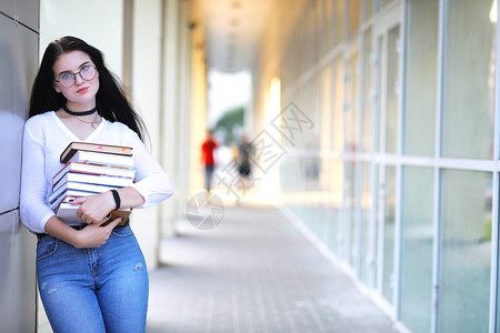 街上背着书包和书的年轻女学生图片