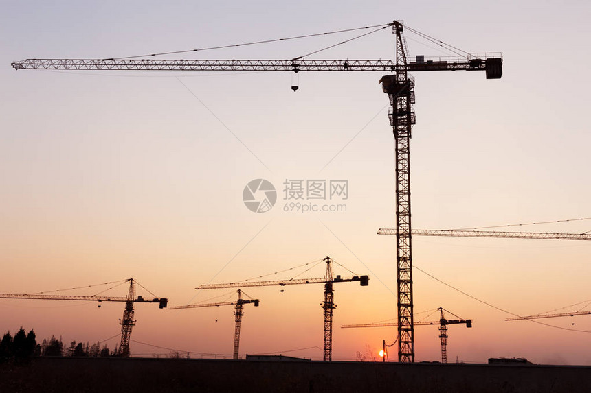 建筑工地夕阳下的工业起重机图片