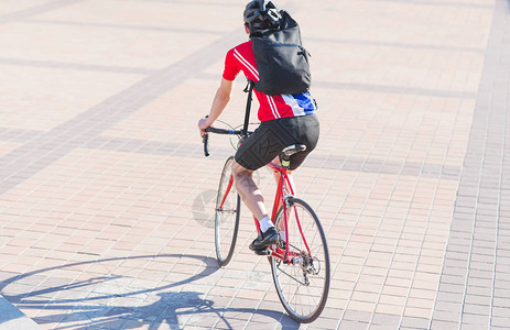 骑自行车的人戴着头盔运动服和背上的背包图片