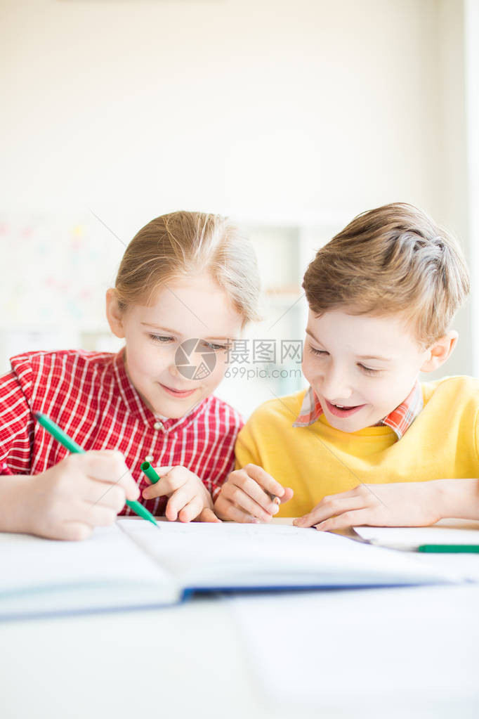 美丽的女学生画着绿色的亮点与她惊人的同学在附图片