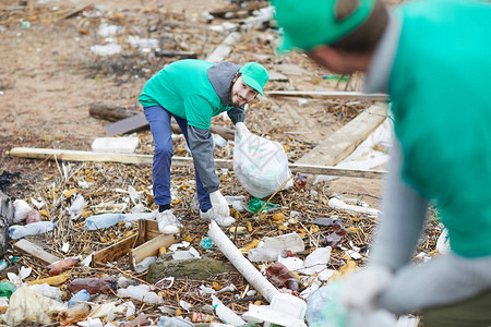 环保公司工人从地上捡起不可回收垃圾图片