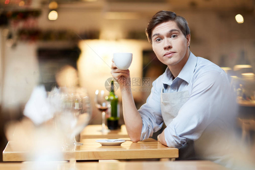 年轻商人辛勤工作后在餐馆喝咖图片