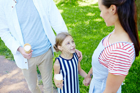 有冰淇淋的可爱女孩和她妈说话同时在暑图片
