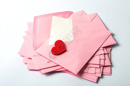 特写堆叠粉色信封和邮件信纸和红色赫拉特图片