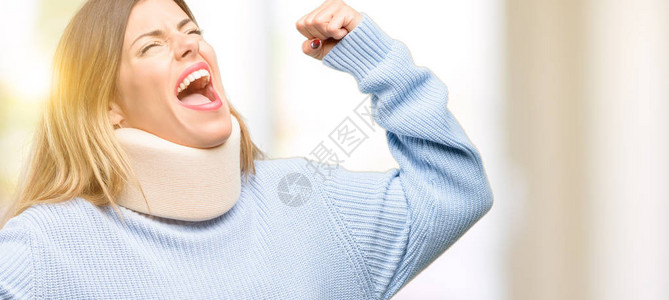 戴着颈托项圈的年轻受伤妇女快乐而兴奋地庆祝胜利图片