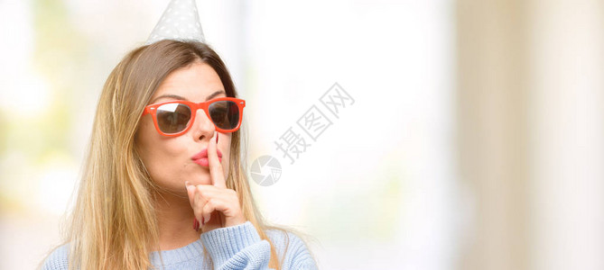 年轻女子用食指在嘴唇上庆祝生日图片