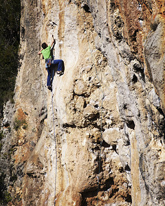 男子攀岩者攀岩者爬上石墙男人做图片