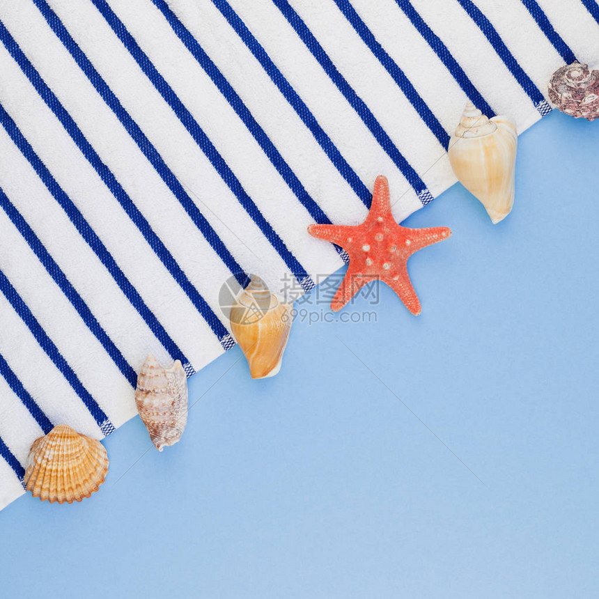 淡蓝色背景上沙滩巾贝壳和海星的顶视图图片