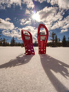 红雪鞋雪鞋和背包站在山上的雪地图片