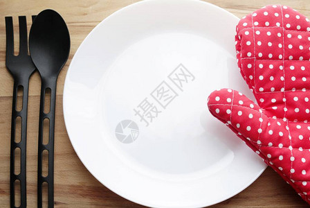 木桌上的白盘子和红手套图片