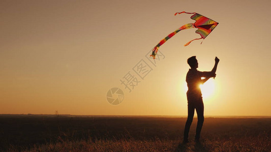 一个青少年在日落时发射风筝图片