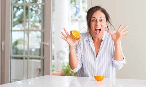 中年妇女拿着橙水果图片
