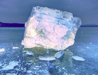 一大块天然冰块在冰冻的湖面绿蓝色平冰上背景图片