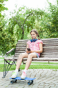 女孩在公园里坐在长椅上坐图片