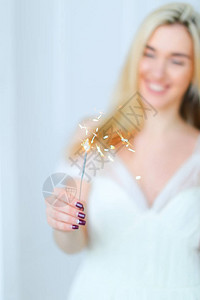 金发快乐的女人保持青春光亮穿着白裙子幸福和庆祝节日的概念图片