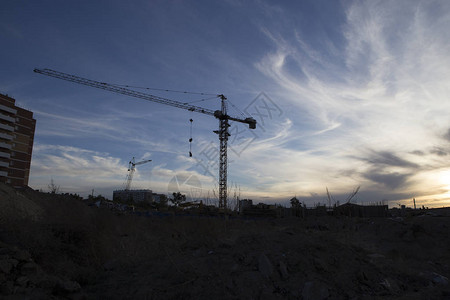 在傍晚的天空背景下建造一座16层建筑的塔式起重机图片