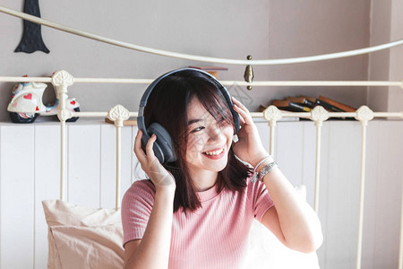 女人在床上用耳机听音乐图片