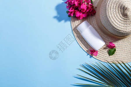 夏季脱暑带帽子的海滩背景布加林亚花奶油和棕榈树枝图片