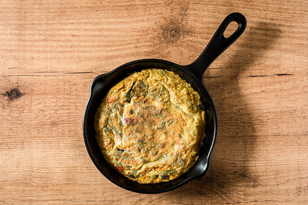 Frittata由铁锅里的鸡蛋和蔬菜制成图片
