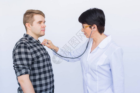 医生用听诊器在白色背景下听病人胸部图片