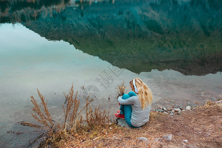 在山湖水边听音乐的女人图片