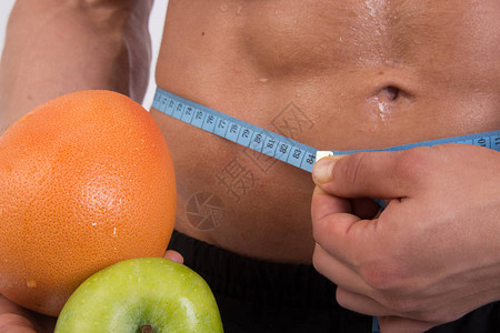 运动和饮食有肌肉的身体的有魅力的人健壮的家伙和水果测量卷尺身体的图片