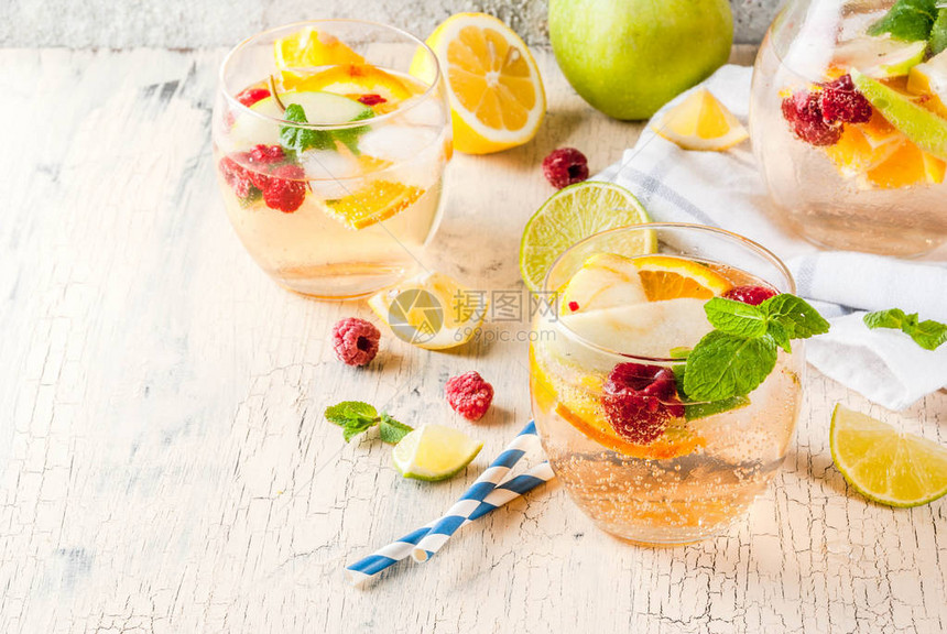 夏季寒冷鸡尾酒水果和子白莓加苹果柠檬橙子和草莓浅混凝土背图片