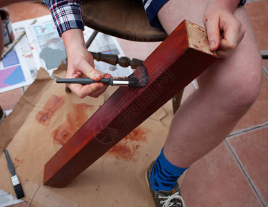 拿着和画木桌腿画笔在手DIY或自己动手画木头的概念家居装修和木背景图片