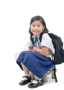 带书包的亚洲女学生坐在木椅上图片