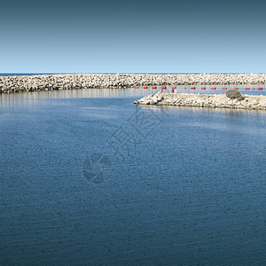 保护地中海滩的防波堤在以色列漂浮在特拉维夫港的红色浮标图片