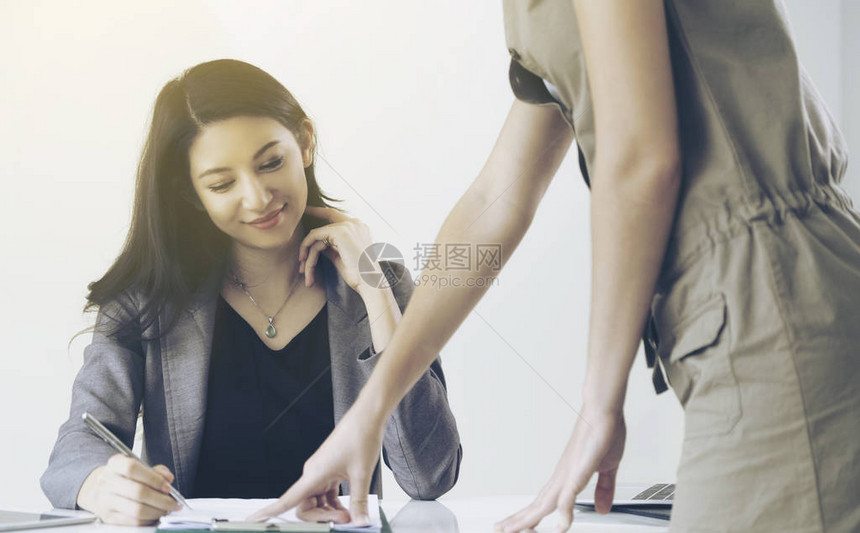 女商人在办公室与站在她合作伙伴面前的另一位女商人讨论时图片