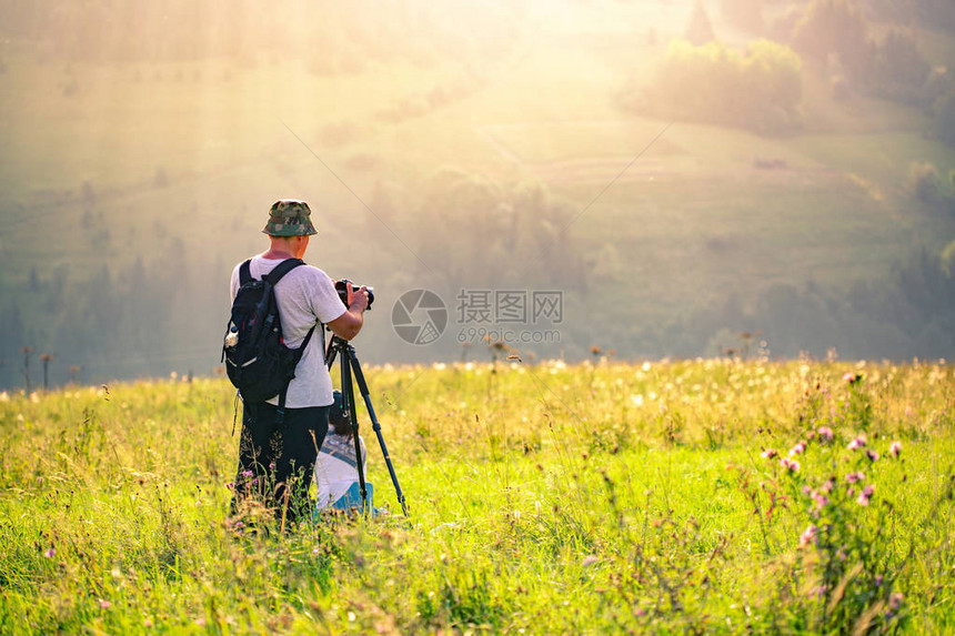 摄影师在山上拍摄日落时的风景图片