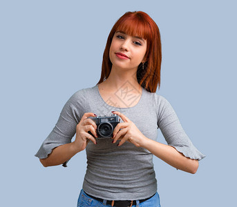 年轻红发女孩拍蓝底照的图片