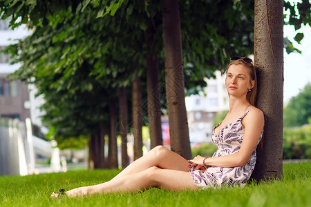坐在绿草地上休息的美丽年轻和快乐图片