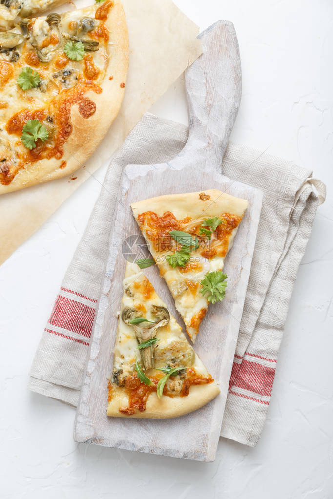 两块披萨白色切白板上配有叶托克的两块披图片