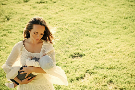 妈照顾母亲在绿草上拥抱小儿子家庭图片