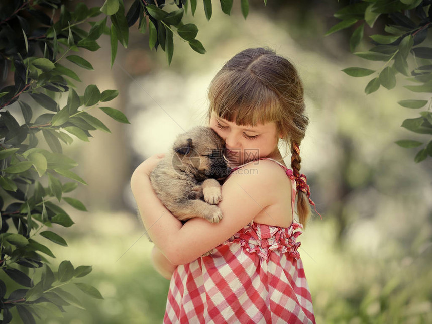 小女孩与闭着眼睛的小可爱女孩轻地拥抱一只小狗图片