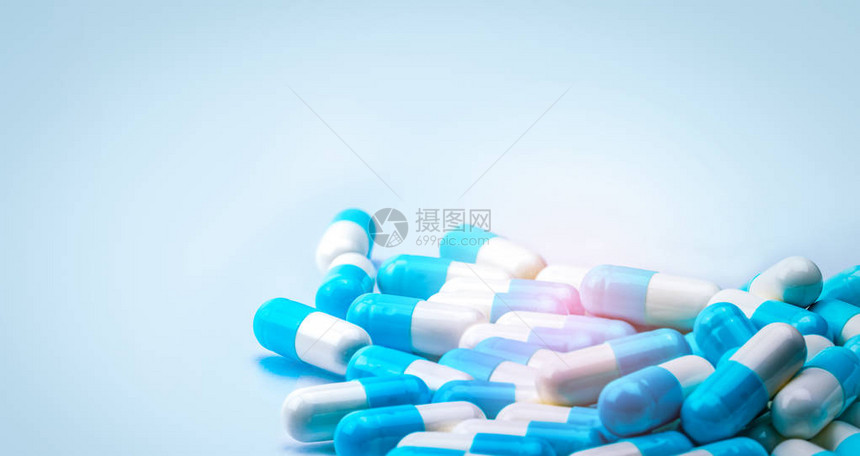 有选择地专注于蓝色和白色胶囊丸散布在带有阴影的白色背景上全球医疗保健概念抗生素耐药抗菌胶囊图片