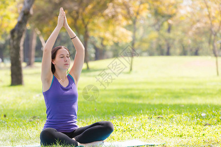 做瑜伽的假日年轻妇女在公共园体育健康概念图片