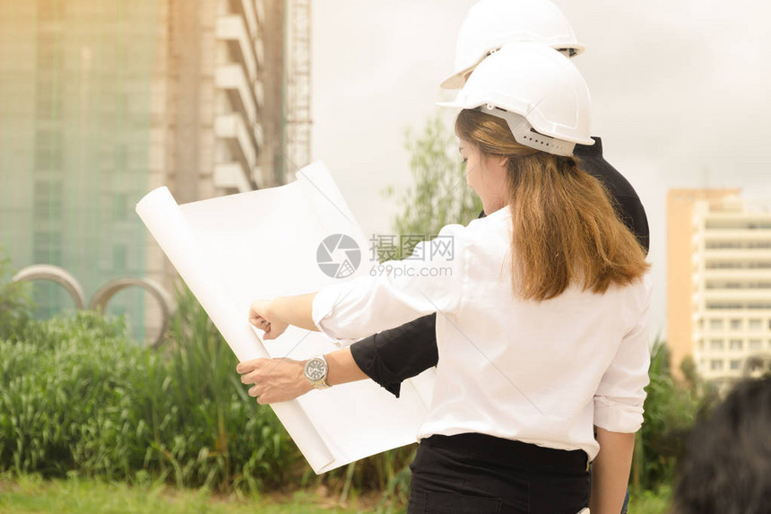 亚洲男女工程师在现场进行计划施工图片